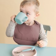 Dziecko samodzielnie spożywa posiłek korzystając z akcesoriów silikonowych od marki Done by Deer.