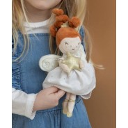 Dziewczynka trzymająca w dłoniach pluszową lalkę.