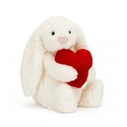 Pluszowy króliczek w kolorze kremowym z czerwonym sercem.